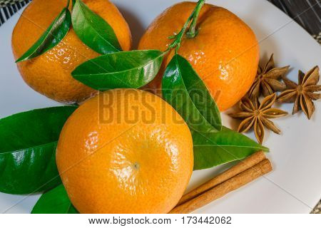 Fresh mandarins on the white plate with spice
