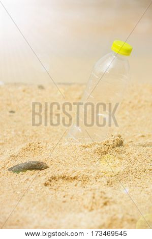Bottle emtry on the sand behind beach with sunlight.