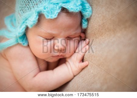 Newborn baby sleeping on a blanket. Hands under cheek