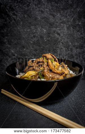 Asian rice with beef meat and vegetagles on dark background