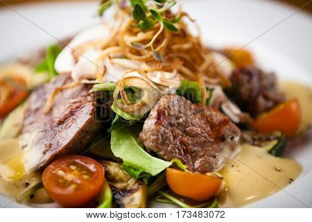 Brutus salad with beef tenderloin served on a plate