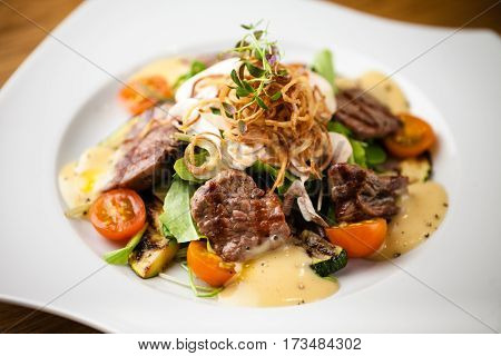 Brutus salad with beef tenderloin served on a plate