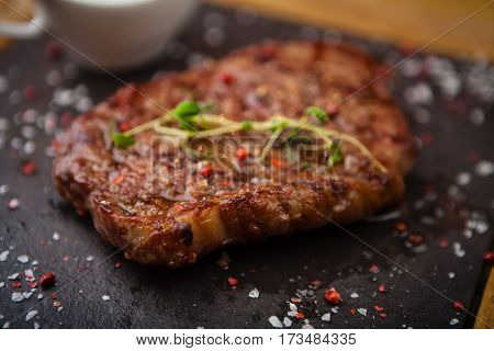 Prime Black Angus New York strip steak served on a warm stone board