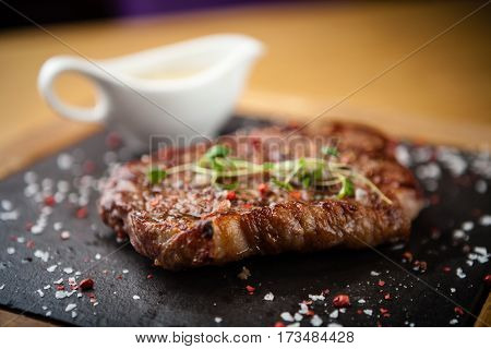 Prime Black Angus New York strip steak served on a warm stone board