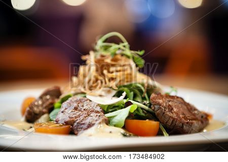 Brutus salad with beef tenderloin served on a plate