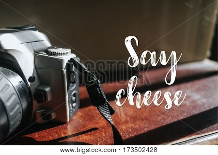 Isolated calligraphy on Camera film on brown wooden stairs. Quote about photo and photography. Say cheese.