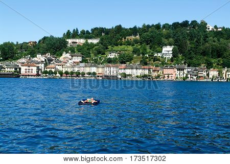 Man On An Inflatable Mattress Sunbathing In Front Of Orta