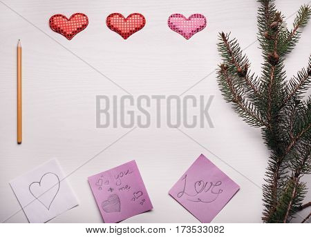 Wooden White Background With A Branch Of Pine And Three Hearts.