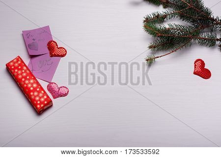 Wooden White Background With A Branch Of Pine And Three Hearts.