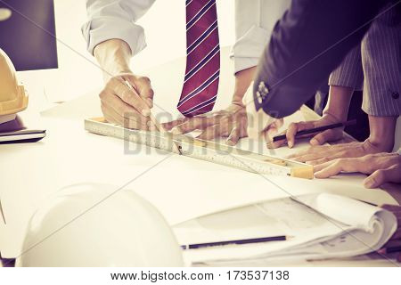 Image of engineer meeting for architectural project. working with partners and engineering tools on workplace. Soft focus and vintage tone effect filter