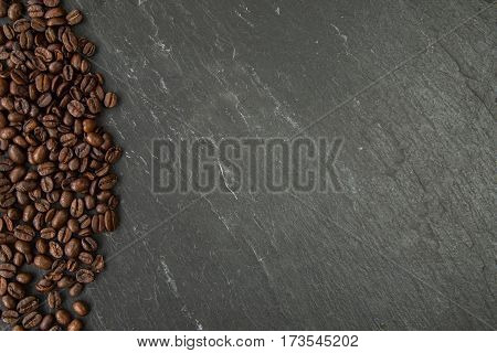 Coffee beans along left side of a slate board