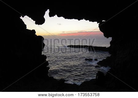 View onto the ocean during sunset through one of the windows at the Ana Kakenga Cave or two windows cave in Easter Island Rapa Nui Chile South America