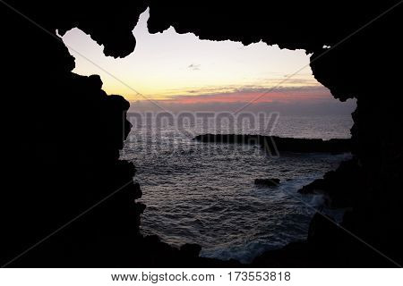 View onto the ocean during sunset through one of the windows at the Ana Kakenga Cave or two windows cave in Easter Island Rapa Nui Chile South America