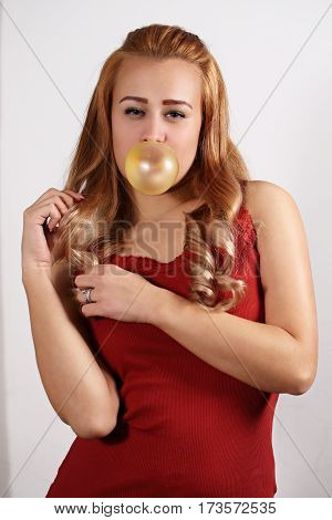 Young woman making a big bubble with a chewing gum