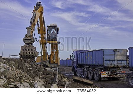 SNEEK, THE NETHERLANDS - MARCH 6, 2017: A Liebherr LH24 mobile crane with hydraulic elevated cab and equipped with a sorting grapple is removing debris from a pile. Focus on cabin of crane.