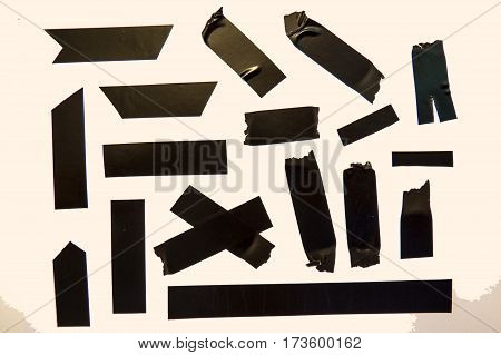 A collection of used black adhesive tape pieces