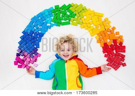 Child Playing With Rainbow Plastic Blocks Toy