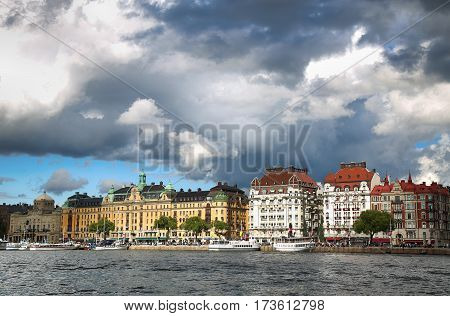 STOCKHOLM SWEDEN - AUGUST 20 2016: Many people walk and visit on Strandvagen street on Ostermalm distric with touristic sightseeing boats in Stockholm Sweden on August 20 2016.