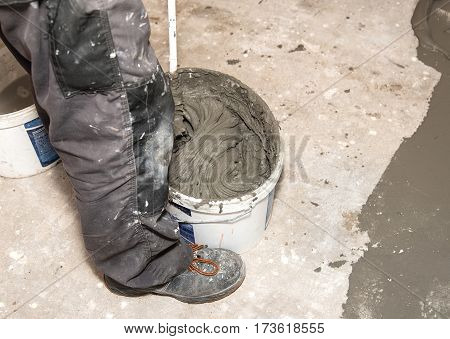 Workers Mixing The Adhesive In Construction