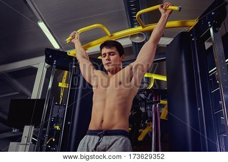 Athlete makes pulling up in the gym.