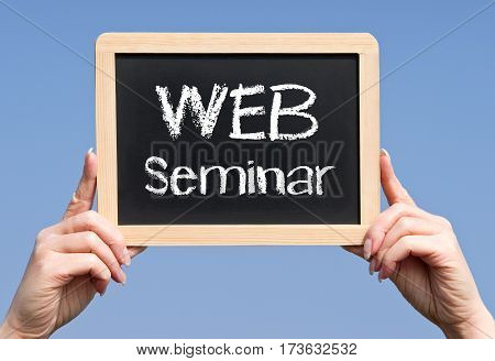 WEB Seminar - female hands holding chalkboard with text