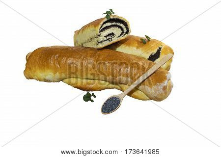Сut poppy roll baked at home with sprigs of mint with a wooden spoon filled with grains of poppy. Isolated on white background.