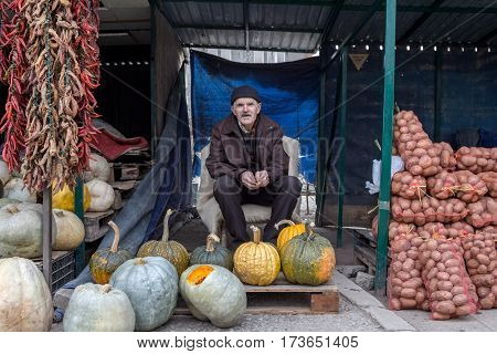 GJILAN - GNJILANE, KOSOVO - JANUARY 02, 2016: Old man in the local market selling vegetables