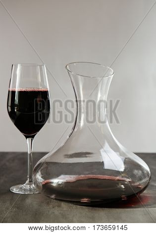 Glass carafe of red wine on gray table