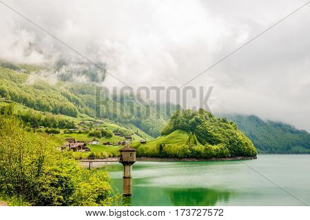 Beautiful emerald mountain lake Lungern in Switzerland under low clouds