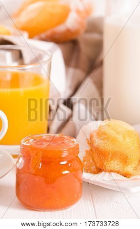 Breakfast with plumcake and orange juice on white dish.