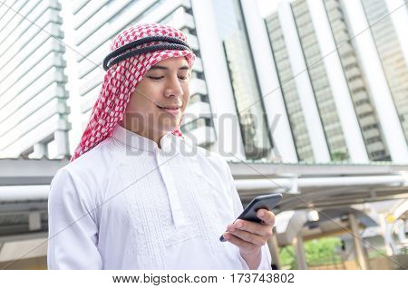 Young Arab businessman using mobile phone while walking in the city. business travel and mobile roaming concepts.