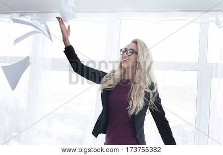 Young businesswoman throws paper document pages in office.