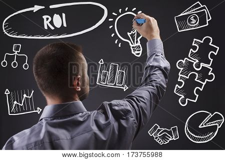 Technology, Internet, Business And Marketing. Young Business Man Writing Word: Roi