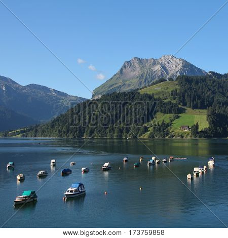 Summer scene in the Swiss Alps. Fishing boats on lake Wagital Schwyz Canton.