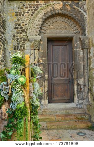 Church's old vintage door in France. Green plants.