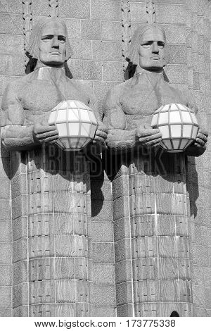 HELSINKI FINLAND SEPTEMBER 25 2015: Statues holding the spherical lamps at the Helsinki Central railway station is a widely recognised landmark in Kluuvi, part of central Helsinki