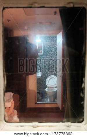 BAR, MONTENEGRO - AUGUST 09, 2016: bare feet and toilet in a crew cabin on a ferry-boat that connects Bar in Montenegro to Bari in Italy
