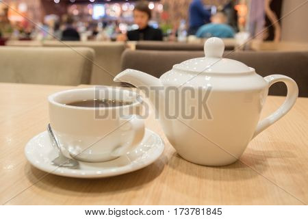 Teapot and cups are prepared for tea drinking in cafe