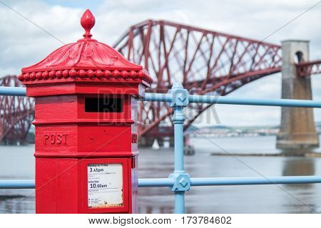Red letterbox and Firth of Forth rail bridge in Edinburgh, Scotland UK