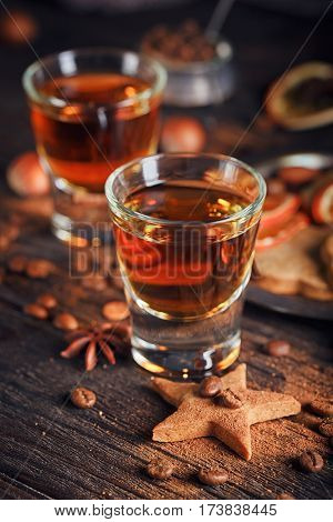 Whiskey or liqueur cookies spices and decorations on wooden background. Seasonal holidays concept.