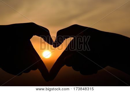 Silhouette SunsetHeart shaped hand dark and contrast