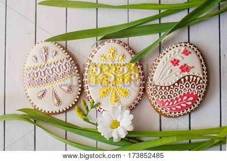 decorated Easter cookies on wooden background. Colored eggs
