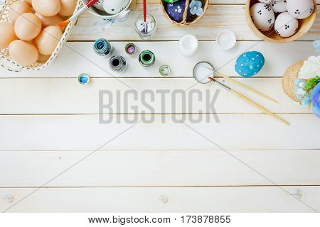 Top view accessories happy Easter festival background.Preparation items handmade painted cute easter eggs for children on rustic white wooden and decoration beautiful flower color with copy space.
