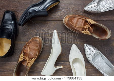 Top view fashionable several design of men and women shoes on wooden floor with copy space.
