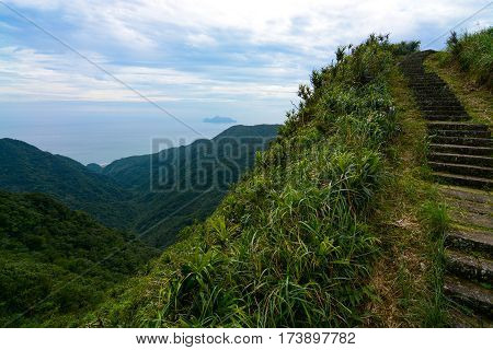 Steps along a steep ridge on the Caoling Historic Trail in Taiwan, with Turtle Island in the background