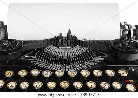 Old antique vintage portable typewriter close-up of a mechanism font and a blank sheet of paper. Antique typewriter in black with white keys of the Polish alphabet. The device isolated on a white background with light shadow and reflection.