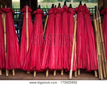 stack of red umbrella and wooden bamboo