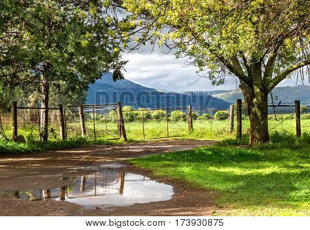 Rural landscape with sun breaking though after the rain with hills and cloudsky in background