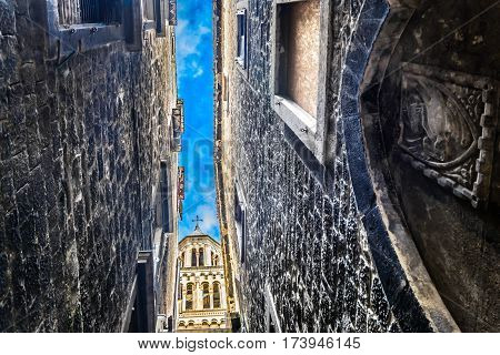 Scenic view at old mediterranean narrow streets in ancient roman town Split with St. Domnius bell tower in background, Croatia.