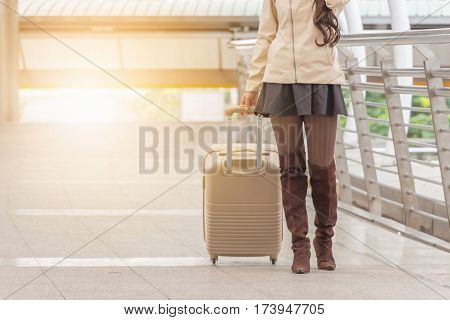 Businesswoman traveler with luggage at city background